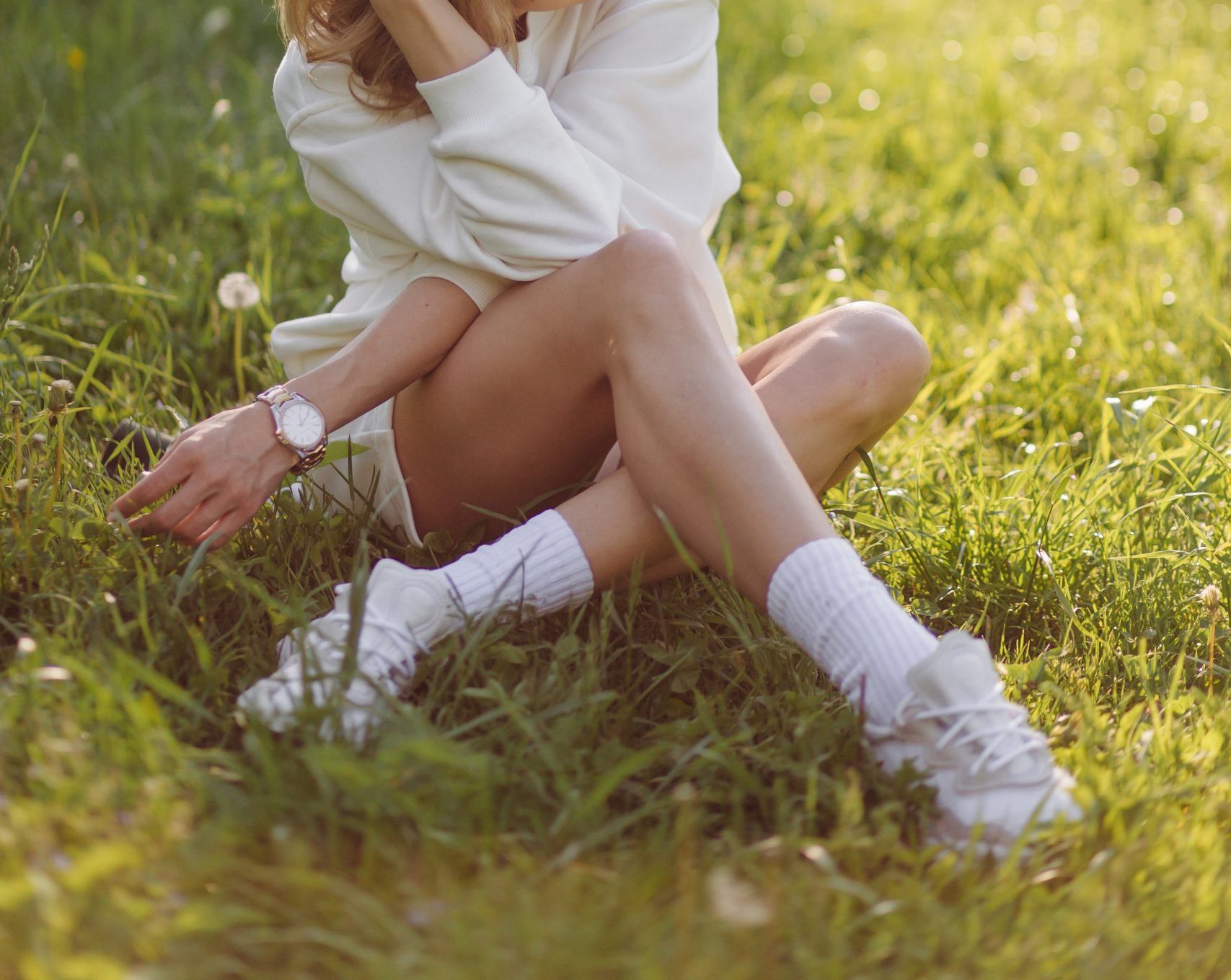 joven rubia lleva una sudadera con capucha blanca sonriendo y caminando en el bosque scaled e1756894320795
