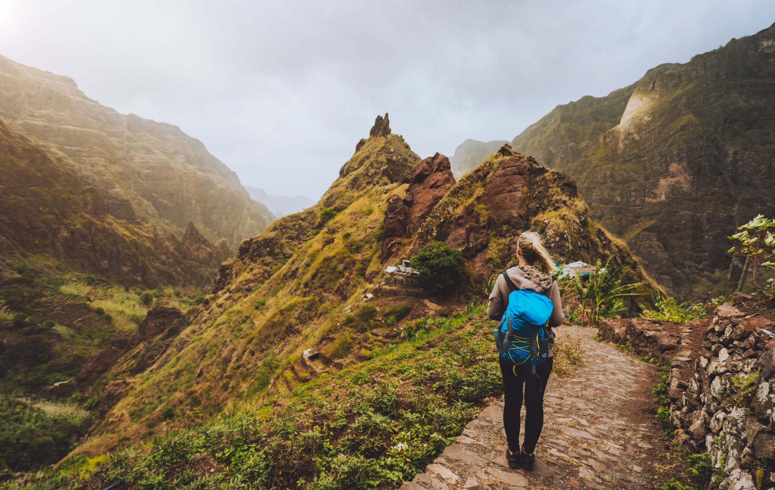 vista trasera de una mujer caminando por un sendero contra las montanas scaled e1756462745254